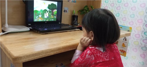 Bé Minh Châu chăm chú xem video truyện: Chó Sói và hai chú Thỏ